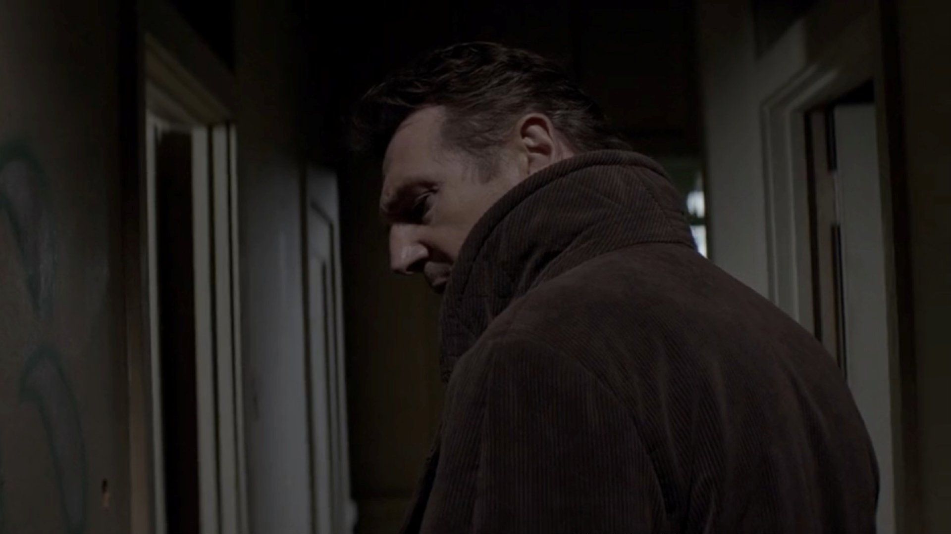 Liam Neeson skulking through a hallway in a scene from the film A Walk Among the Tombstones