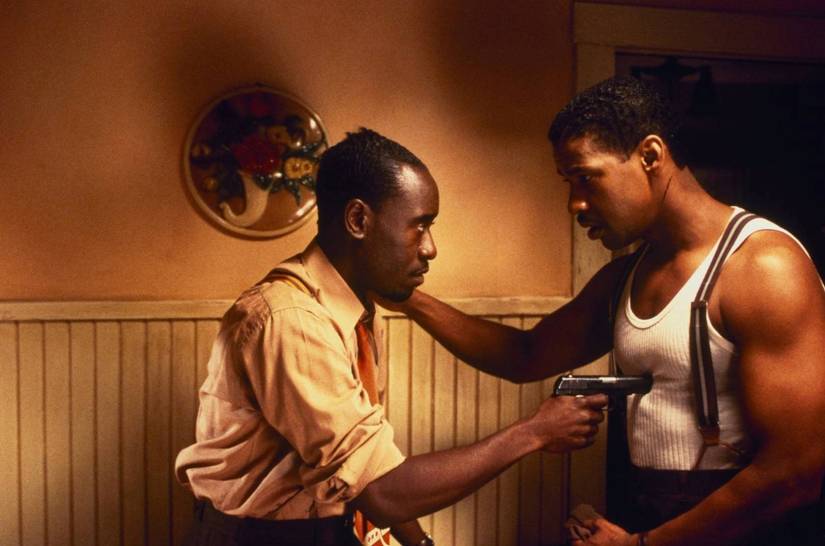 Don Cheadle, tocando el ratón de gatillo de cabello, sostiene una pistola para el detective Easy Rawlins, interpretado por Denzel Washington, en una escena de Devil in a Blue Dress
