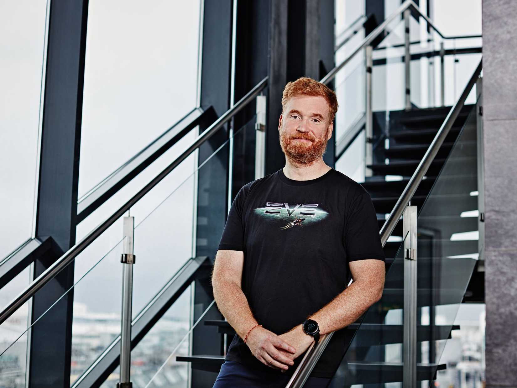 Hilmar Petursson, CEO of CCP, stands on a staircase wearing an Eve Online T-shirt