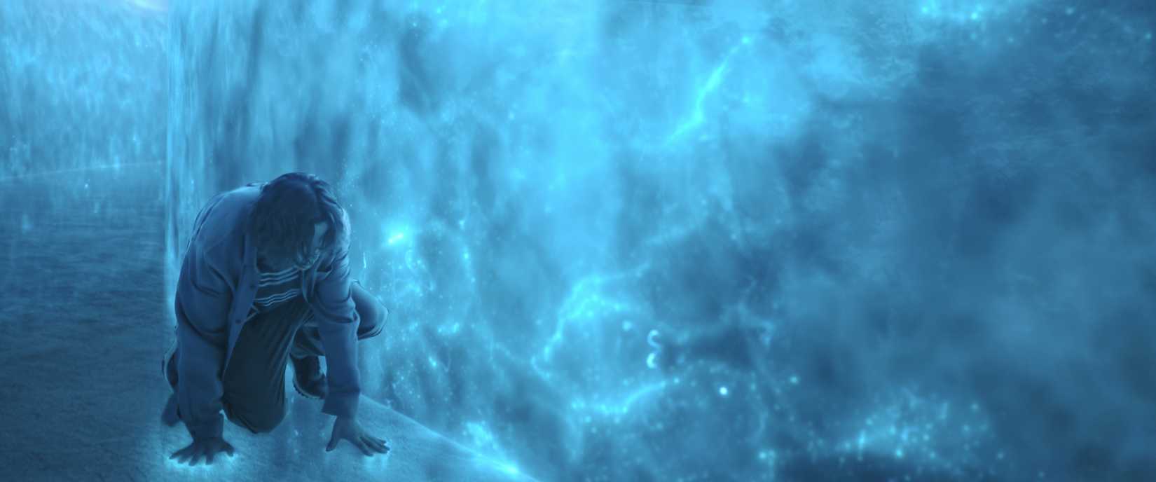 एक आदमी विदेशी तकनीक से बने एक कमरे में क्राउच करता है। दीवारें और फर्श नीले रंग की होती है और जैसे कि बिजली के भीतर से जलाया जाता है।