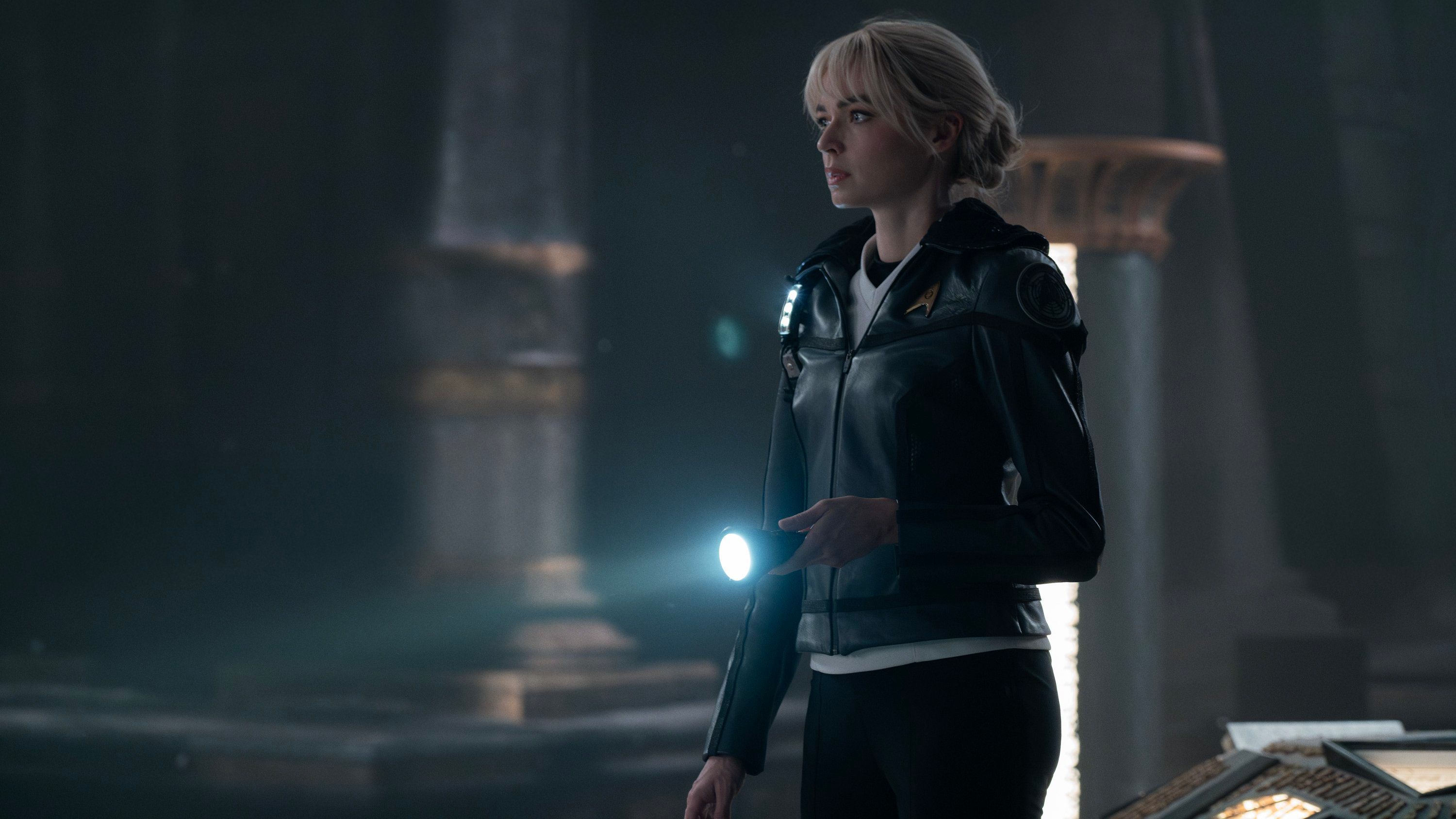 Jesse Bush como Christine Chapel tiene una linterna mientras explora un templo alienígena en Star Trek: Strange New Worlds