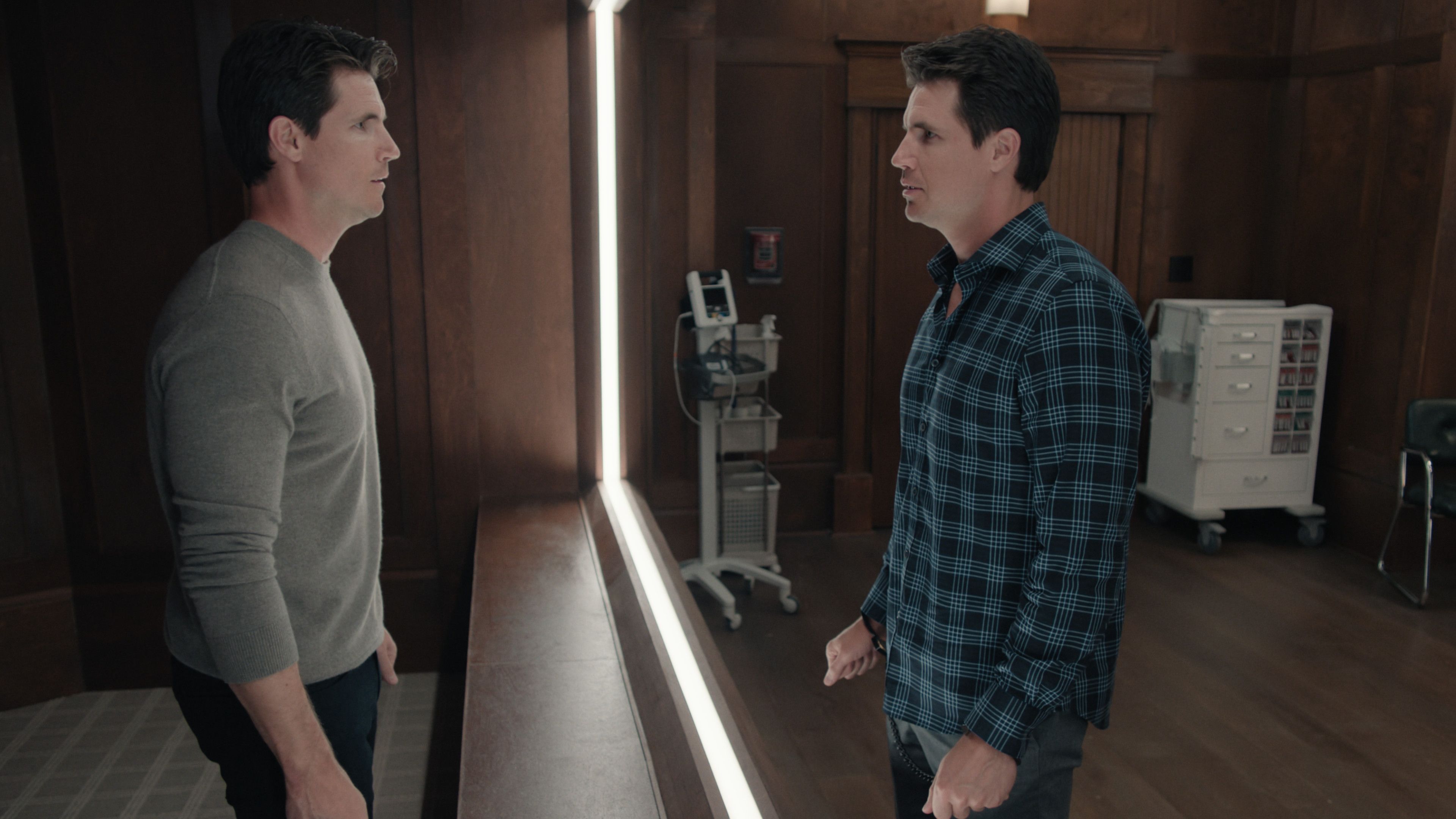 Robbie Amell looks at a copy of himself in a mirror in Upload