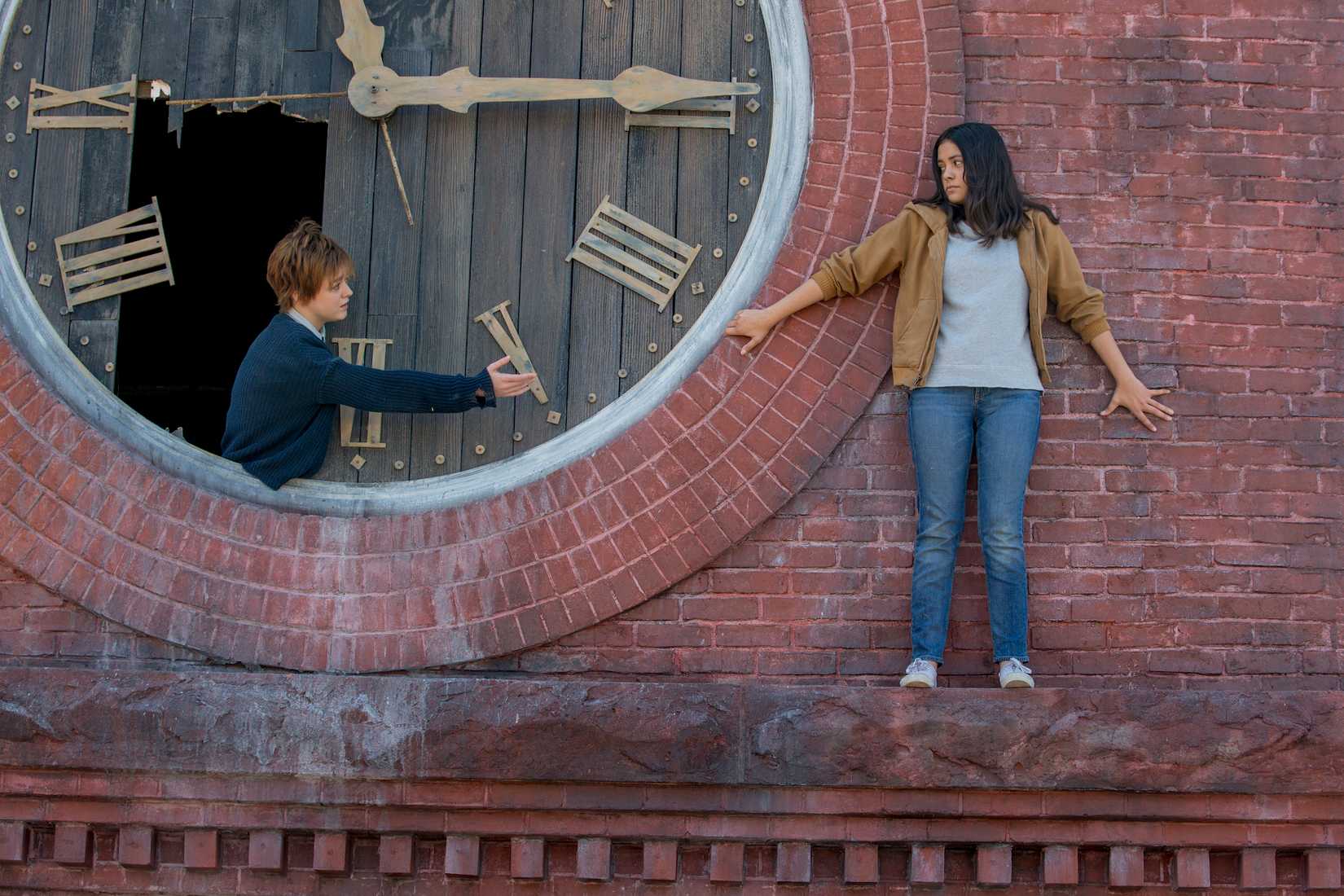 Rahne Sinclair (Maisie Williams) usada entre mesas quebradas em um relógio de pico, suavize um acordo 