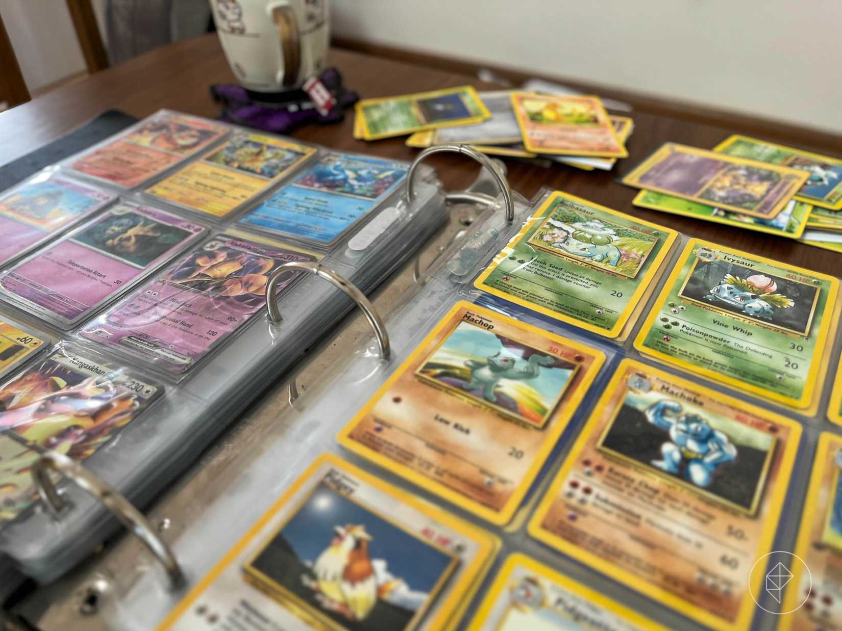 An photo of two pages of a three-ring binder open with Pokémon cards. It shows cards from the Scarlet & Violet—151 set alongside other older cards.