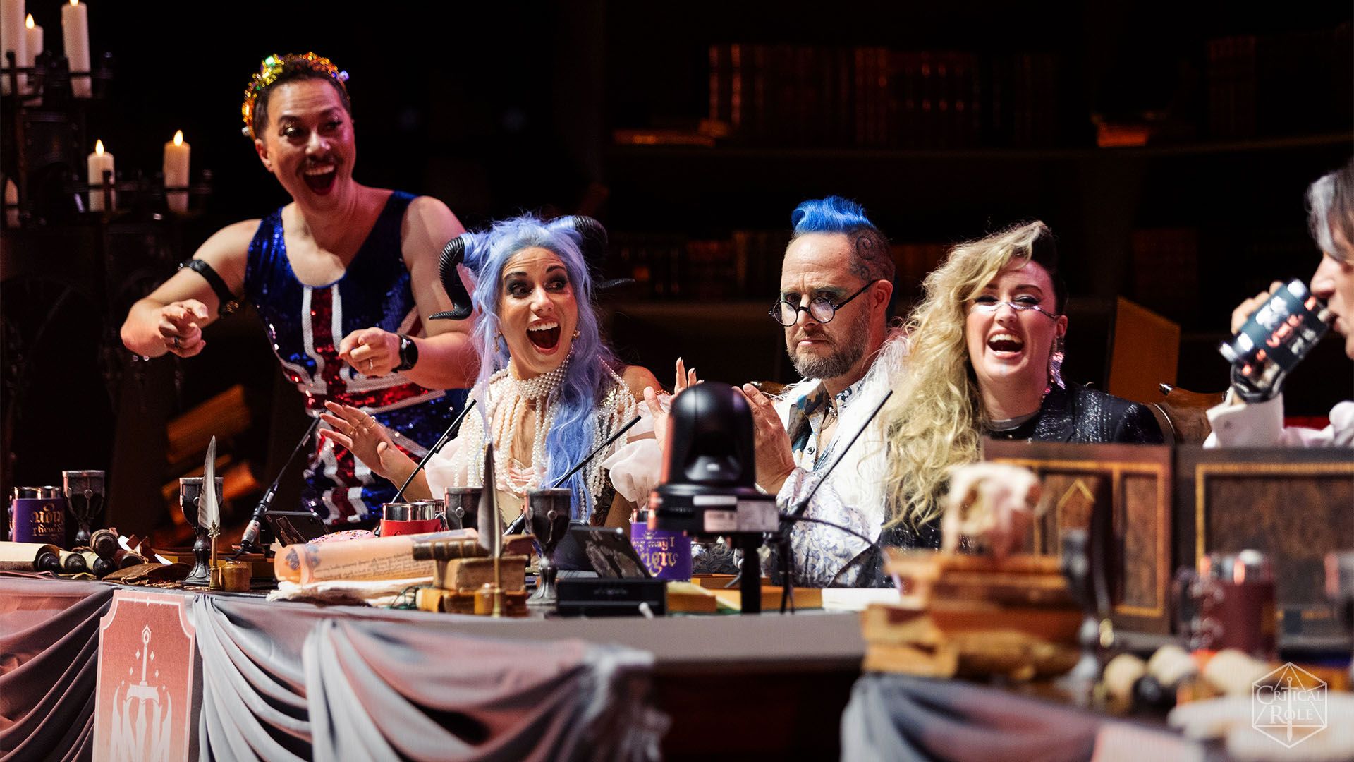 Da esquerda para a direita, Sam Riegel, Laura Bailey, Taliesin Jaffe e Ashley Johnson no palco em Londres em outubro de 2023. Durante o show de Wembly Arena, eles usavam figurinos elaborados, incluindo o Union Jack Onesie de Riegel.